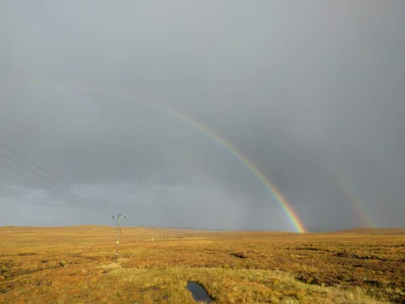 The landscape of the Isle of Lewis. Flat, wet peat bog with rain imminent and stunning rainbows for dramatic effect.
